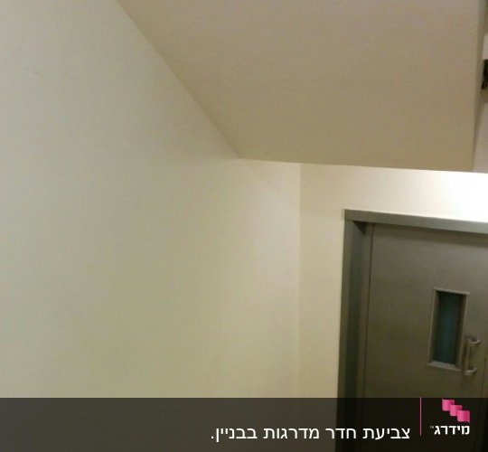 קיר צבוע בלבן ליד דלת אפורה